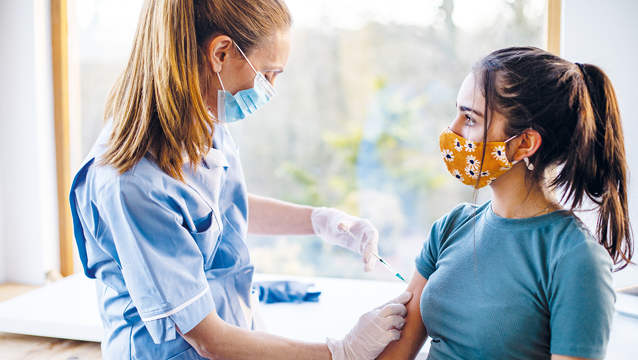 CQC annual report 2020-2021: main image Photo of a woman receiving her Covid-19 vaccination from a nurse
